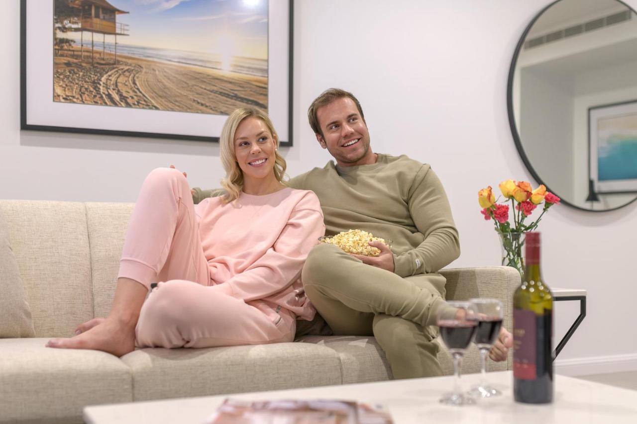 Meriton Suites Surfers Paradise Gold Coast Luaran gambar A couple watching a movie together.